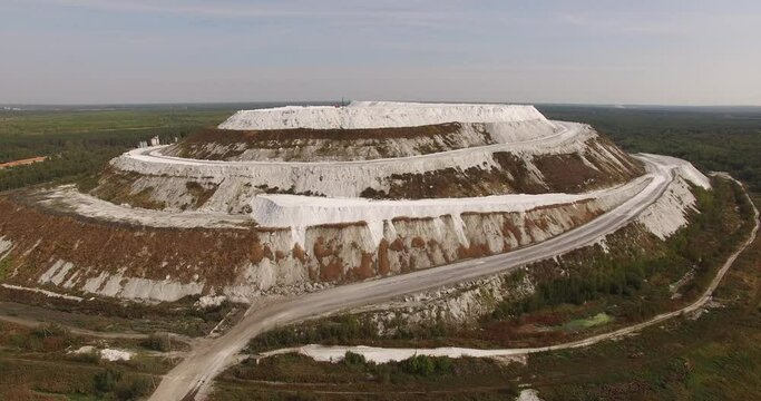 4K sunny morning aerial video of huge industrial phosphorite powder man made "White Mountain" near small town Voskresensk in Moscow Oblast near Moscow, Russia. Phosphorite is still mined there