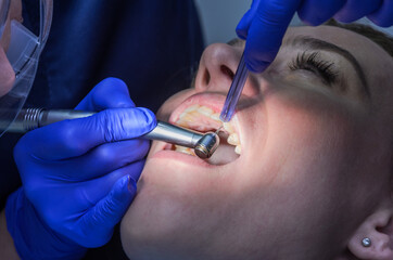 Doctor dentist treats teeth to woman