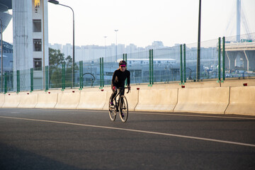 Evening workout of a woman on a bike. Play sports in the city. Yacht Bridge St. Petersburg.