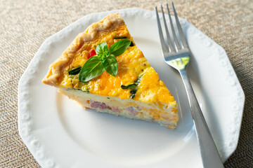 Slice of Quiche Lorraine on a white plate