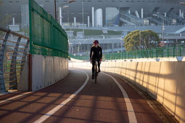 Evening workout of a woman on a bike. Play sports in the city. Yacht Bridge St. Petersburg.