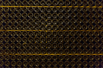 Close up of bottom of dark wine bottles with reflecting light in a bodega in Santa Maria del Cami,...