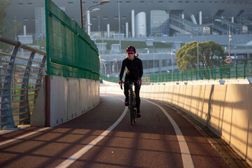 Morning exercise of a woman on a bike in the city. Outdoor sports. Krestovsky Island Saint Petersburg Russia.