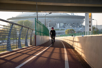 Evening workout of a woman on a bike. Play sports in the city. Yacht Bridge St. Petersburg.