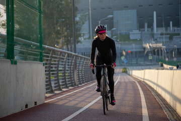 Morning exercise of a woman on a bike in the city. Outdoor sports. Krestovsky Island Saint Petersburg Russia.