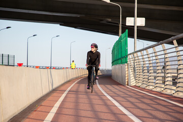 Morning exercise of a woman on a bike in the city. Outdoor sports. Krestovsky Island Saint Petersburg Russia.