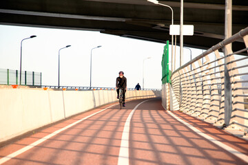 Morning exercise of a woman on a bike in the city. Outdoor sports. Krestovsky Island Saint Petersburg Russia.