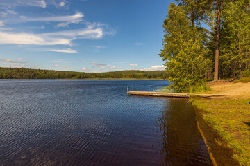 Beautiful view of calm lake water surface with local swimming plays Coast line merges with horizon...