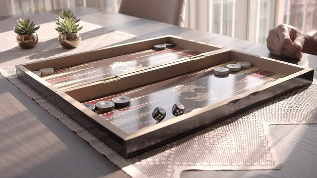 Backgammon is a video that exhibits footage of the traditional Turkish backgammon game board. Hand throws dice in slow motion. You can use this 1920x1080 (HD) bit of video in any project.