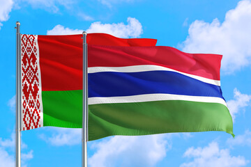 Gambia and Belarus national flag waving in the windy deep blue sky. Diplomacy and international relations concept.