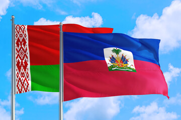 Fototapeta na wymiar Haiti and Belarus national flag waving in the windy deep blue sky. Diplomacy and international relations concept.