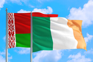 Ireland and Belarus national flag waving in the windy deep blue sky. Diplomacy and international relations concept.
