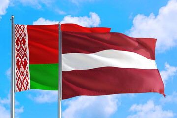 Fototapeta na wymiar Latvia and Belarus national flag waving in the windy deep blue sky. Diplomacy and international relations concept.