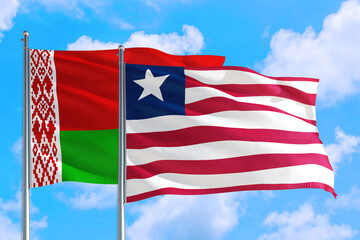 Liberia and Belarus national flag waving in the windy deep blue sky. Diplomacy and international relations concept.