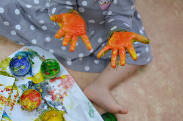 Obraz na płótnie Canvas little girl and boy hands painted in colorful paints, fingers and palms are stained with paint