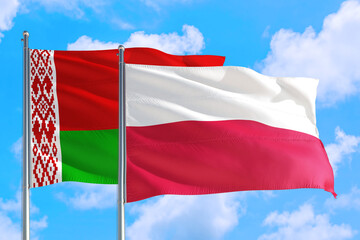 Poland and Belarus national flag waving in the windy deep blue sky. Diplomacy and international relations concept.