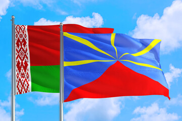 Reunion and Belarus national flag waving in the windy deep blue sky. Diplomacy and international relations concept.
