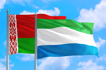 Fototapeta na wymiar Sierra Leone and Belarus national flag waving in the windy deep blue sky. Diplomacy and international relations concept.