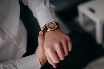 Ein Mann schaut auf seine Armbanduhr, Bräutigam checkt die Uhrzeit 