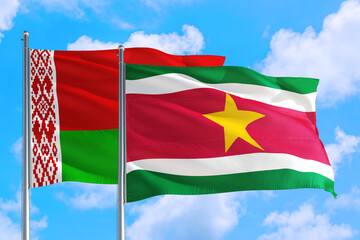 Suriname and Belarus national flag waving in the windy deep blue sky. Diplomacy and international relations concept.