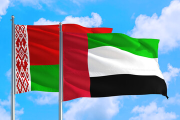 United Arab Emirates and Belarus national flag waving in the windy deep blue sky. Diplomacy and international relations concept.