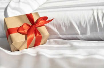 Christmas gift on bed with white bedding. sunny morning with shadow.