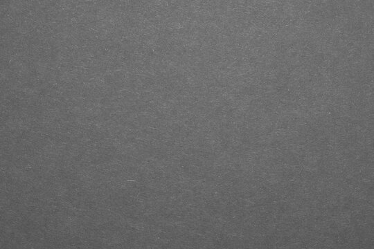 An empty sheet of black paper with visible flecks. Black colored paper texture