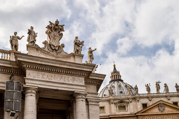 Fototapeta premium Close-up of architectural details of Saint Peter's Basilica and some of the statues on the doric columns that surround Saint Peter's Square. Vatican, Rome, Italy.