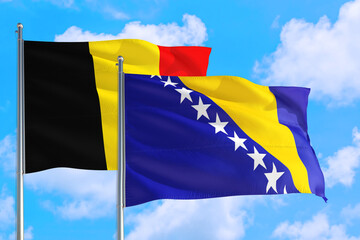 Bosnia Herzegovina and Belgium national flag waving in the windy deep blue sky. Diplomacy and international relations concept.
