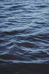 Fototapeta premium Close-up water surface, sun glare and blurred photo. Natural and abstract background.