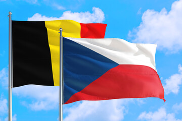 Czech Republic and Belgium national flag waving in the windy deep blue sky. Diplomacy and international relations concept.