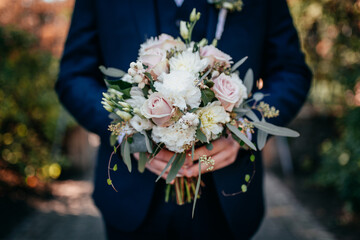 Blumenstrauss in den Händen des Bräutigams am Hochzeitstag