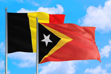 East Timor and Belgium national flag waving in the windy deep blue sky. Diplomacy and international relations concept.