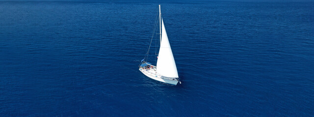 Aerial drone ultra wide panoramic photo of beautiful sailboat cruising the Aegean deep blue sea