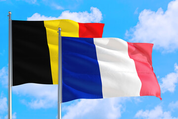 France and Belgium national flag waving in the windy deep blue sky. Diplomacy and international relations concept.