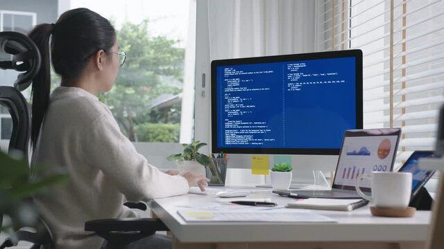 Side view of young asian woman, freelance data scientist work remotely at home coding programing on Big data mining, AI data engineering, IT Technician Works on Artificial Intelligence Project.