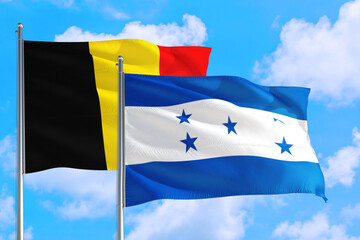 Honduras and Belgium national flag waving in the windy deep blue sky. Diplomacy and international relations concept.