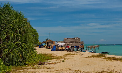East Malaysia. Sea Gypsy village on a sandy coral reef island. The main trade of local residents is fishing and sea Souvenirs