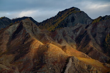 Russia. Mountain Altai. Illuminated by the sunset rays of the sun, the picturesque mountains along the Chui tract near the village of Inya.