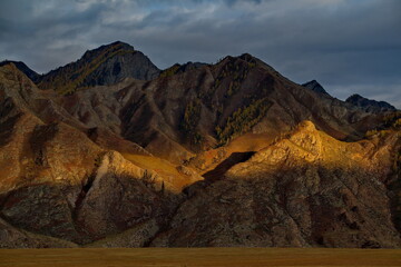 Fototapeta premium Russia. Mountain Altai. Illuminated by the sunset rays of the sun, the picturesque mountains along the Chui tract near the village of Inya.