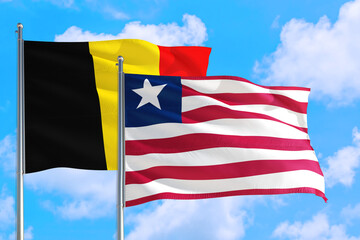 Liberia and Belgium national flag waving in the windy deep blue sky. Diplomacy and international relations concept.