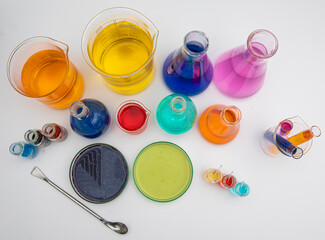 Laboratory glassware with liquids of different colors on white table. Volumetric laboratory...