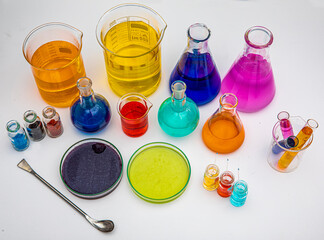 Laboratory glassware with liquids of different colors on white table. Volumetric laboratory...