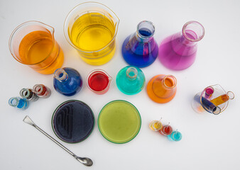 Laboratory glassware with liquids of different colors on white table. Volumetric laboratory...