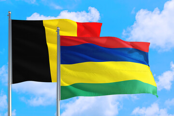Mauritius and Belgium national flag waving in the windy deep blue sky. Diplomacy and international relations concept.