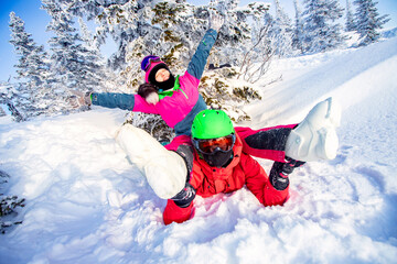 Fototapeta na wymiar Couple happy friends having fun in winter forest. Snowbarders and skiers team friendship