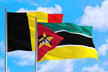 Mozambique and Belgium national flag waving in the windy deep blue sky. Diplomacy and international relations concept.