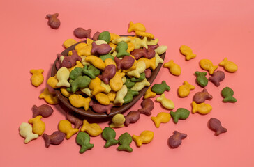 Colorful rainbow goldfish crackers on a pink background