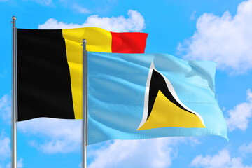 Saint Lucia and Belgium national flag waving in the windy deep blue sky. Diplomacy and international relations concept.