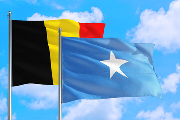 Somalia and Belgium national flag waving in the windy deep blue sky. Diplomacy and international relations concept.